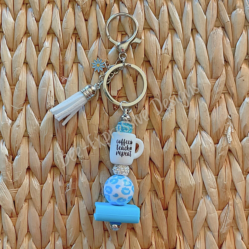 Adorable, handmade, TEACHER keychain with a book, daisy charm, tassel, & a silicone rubber focal cup bead that reads Coffee, Teach, Repeat!