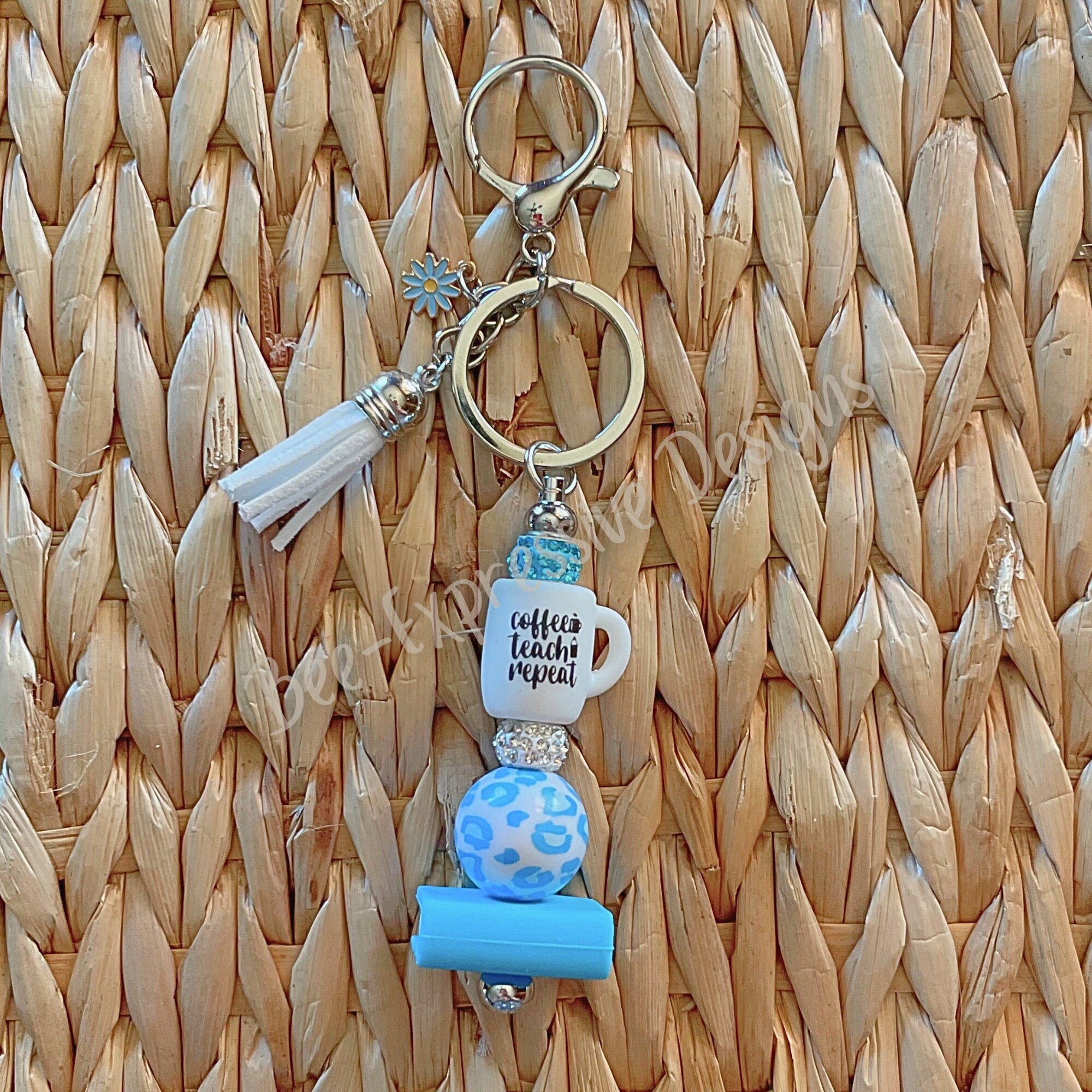 Adorable, handmade, TEACHER keychain with a book, daisy charm, tassel, & a silicone rubber focal cup bead that reads Coffee, Teach, Repeat!