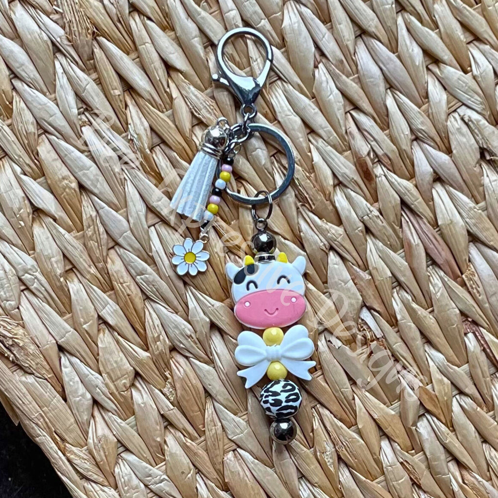 Unique and cute is this silicone cow beaded keychain with a beaded tassel and daisy charm!