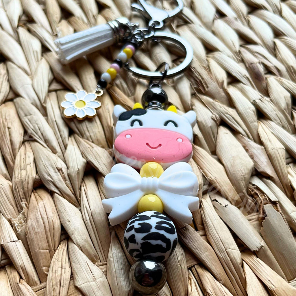 Unique and cute is this silicone cow beaded keychain with a beaded tassel and daisy charm!