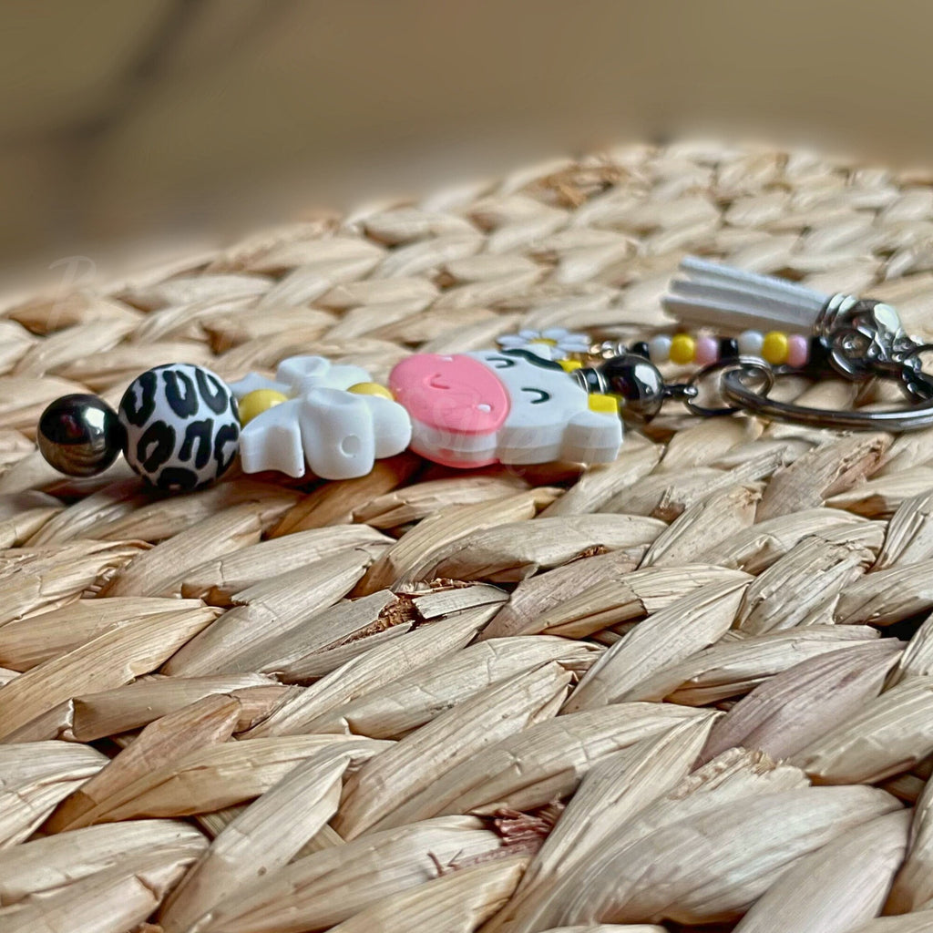 Unique and cute is this silicone cow beaded keychain with a beaded tassel and daisy charm!