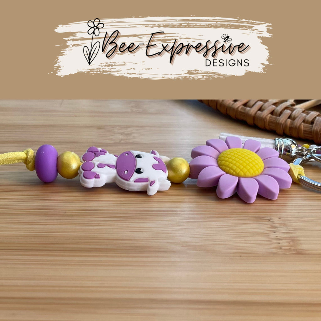 Beaded, purple COW keychain! Lobster or swivel clasp, silicone purple sunflower, yellow suede cord, beaded tassel with a butterfly charm!