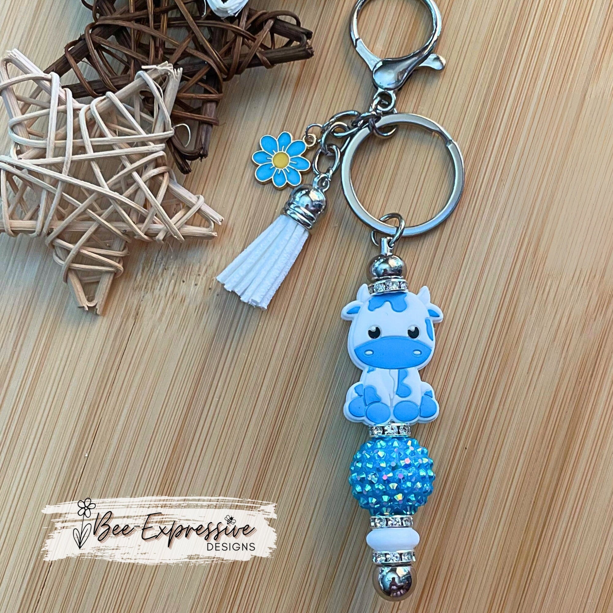 Beautiful handmade baby blue cow keychain with a 20mm rhinestone bead and a daisy charm!