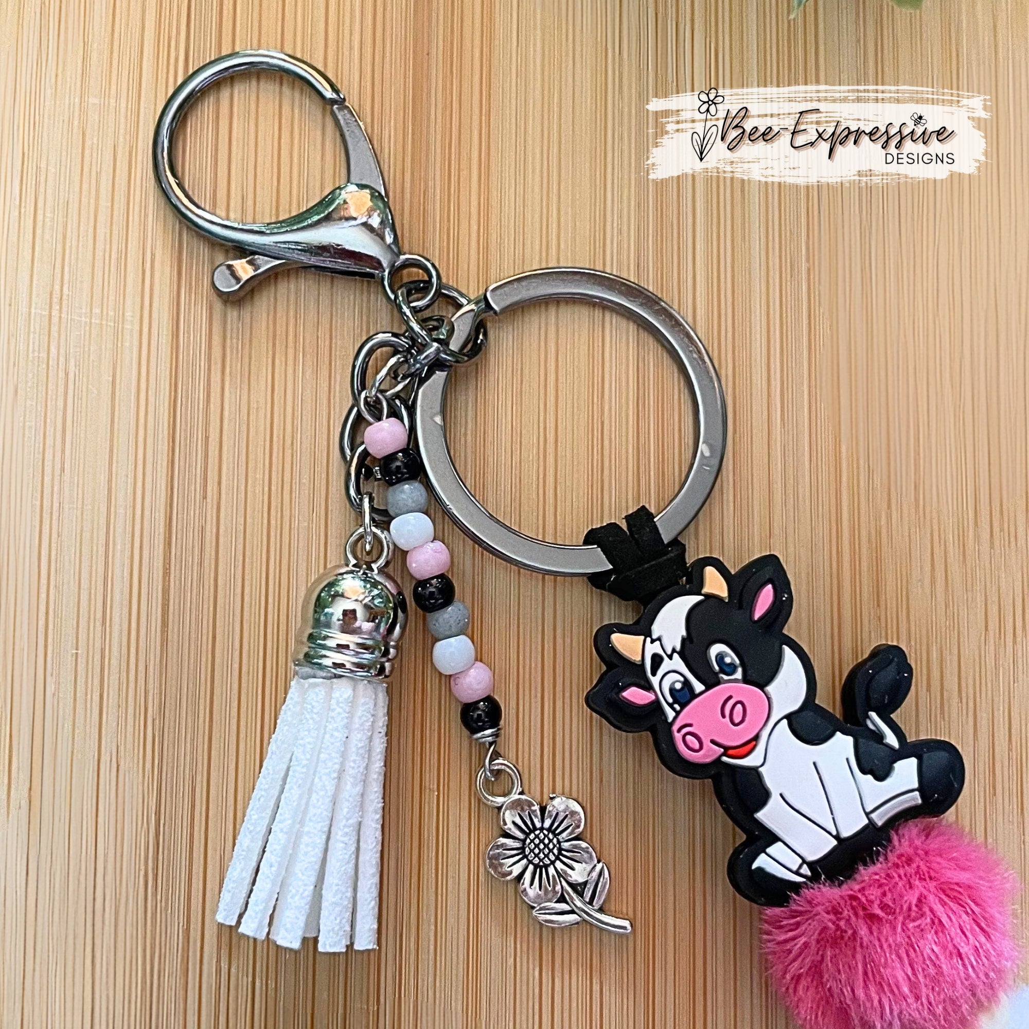 Adorable, handmade, black and white, bull cow keychain! Furry beads, silicone lentil spacer beads, beaded tassel with metal flower charm