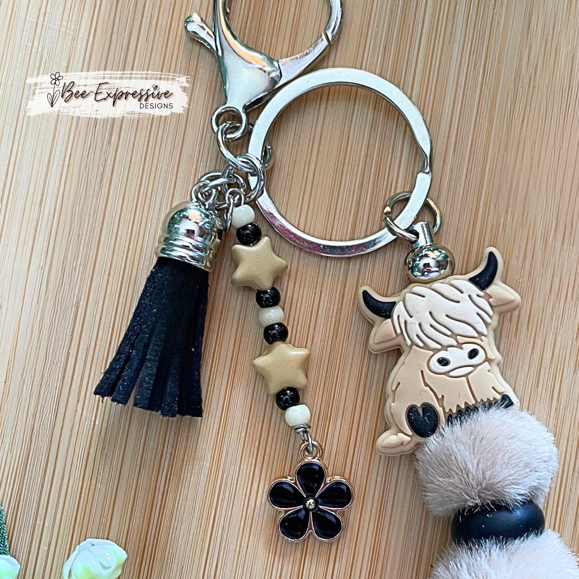 Adorable, handmade, bull cow keychain! Furry beads, silicone lentil spacers, stars, acrylic beaded tassel and black flower charm!