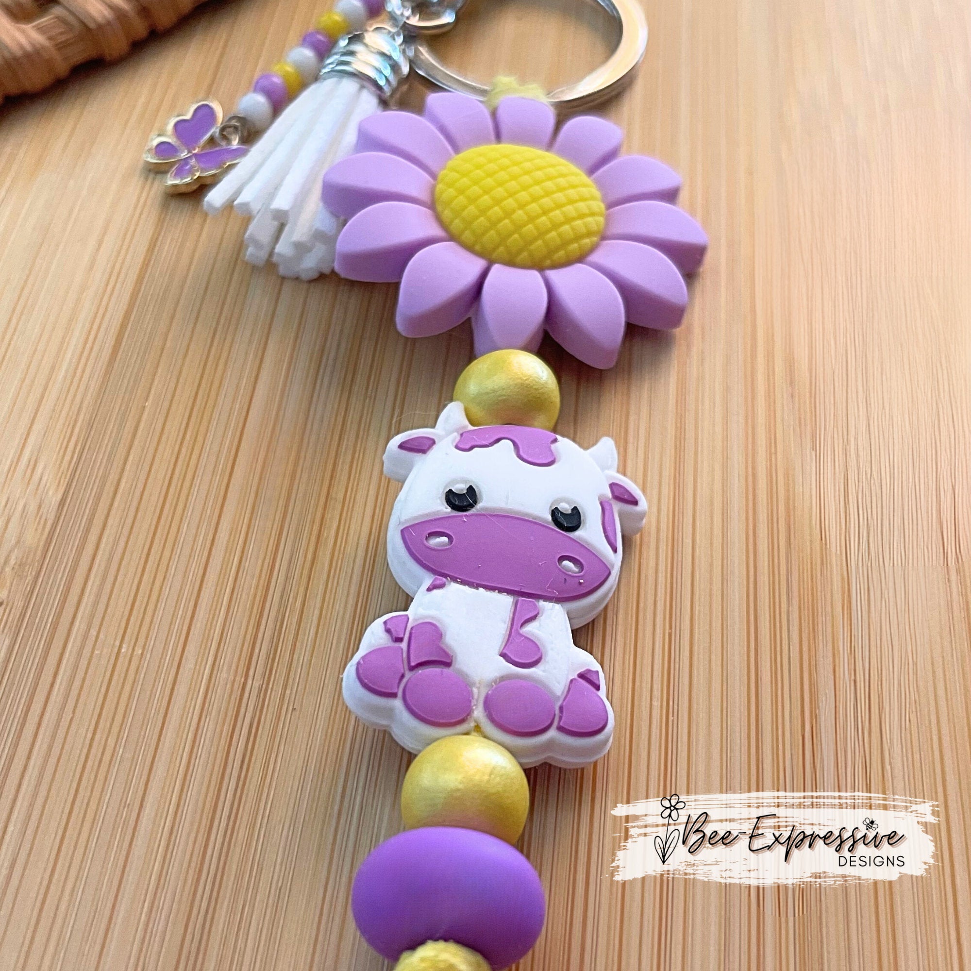 Beaded, purple COW keychain! Lobster or swivel clasp, silicone purple sunflower, yellow suede cord, beaded tassel with a butterfly charm!