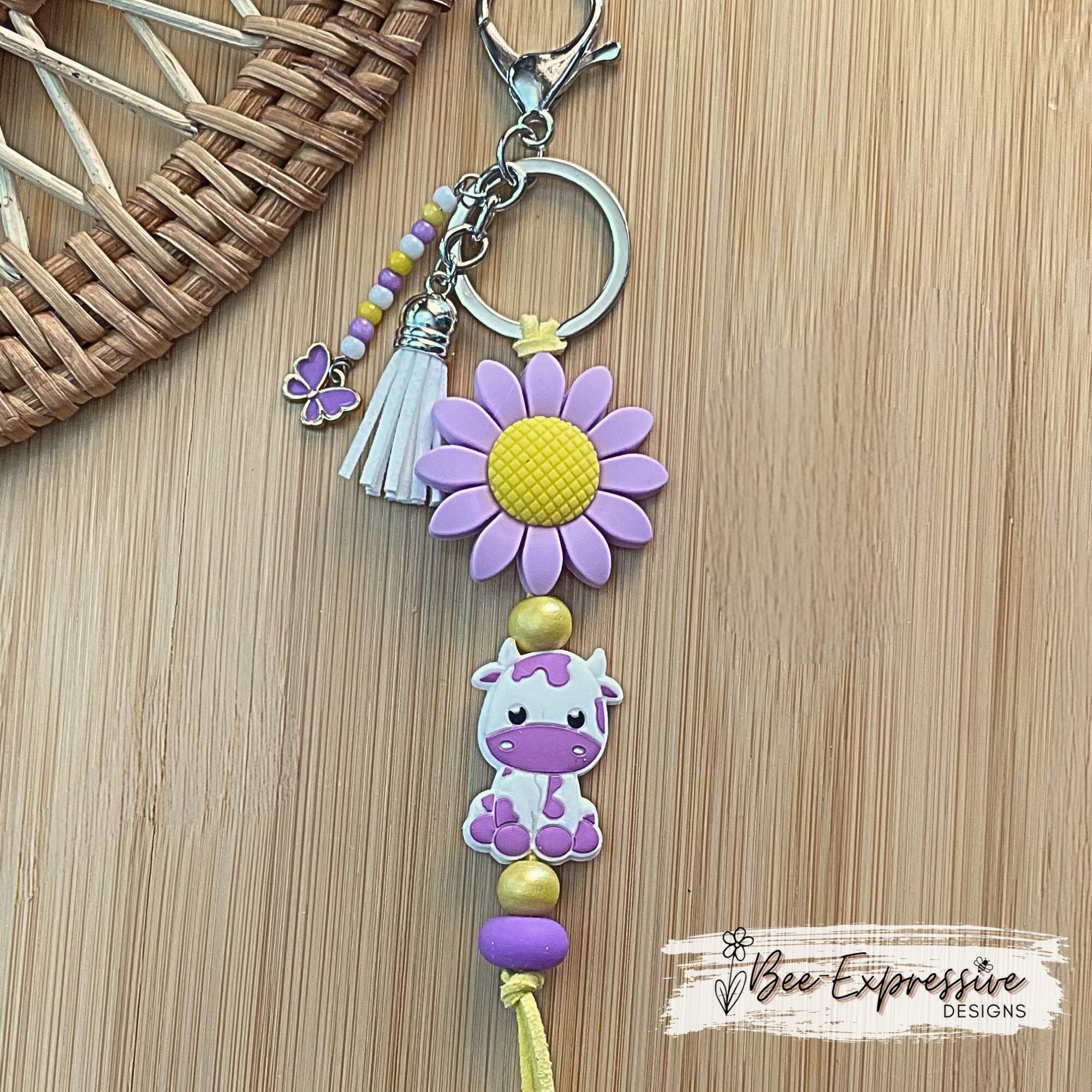 Beaded, purple COW keychain! Lobster or swivel clasp, silicone purple sunflower, yellow suede cord, beaded tassel with a butterfly charm!