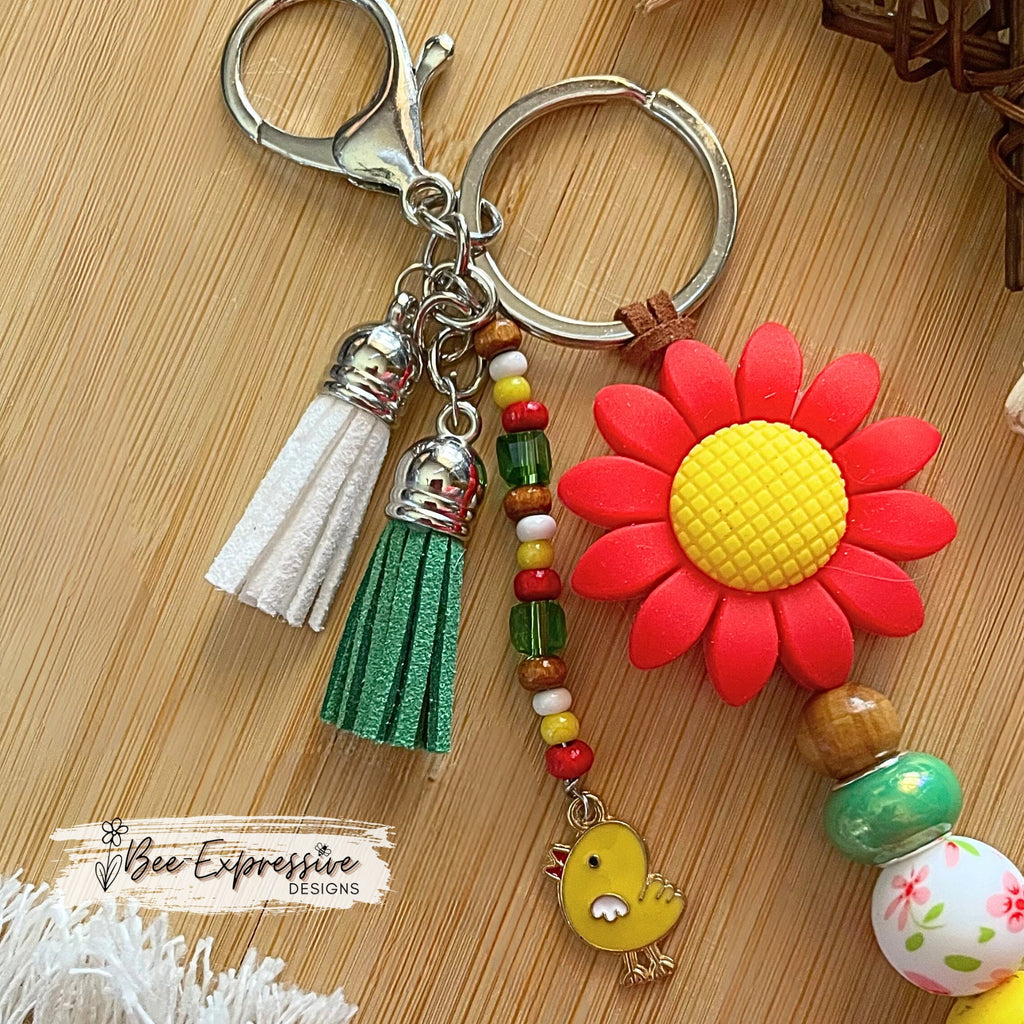 Handmade, vividly colored, silicone sunflower with barn keychain! Lobster clasp on suede cord, beaded tassel with chicken charm,