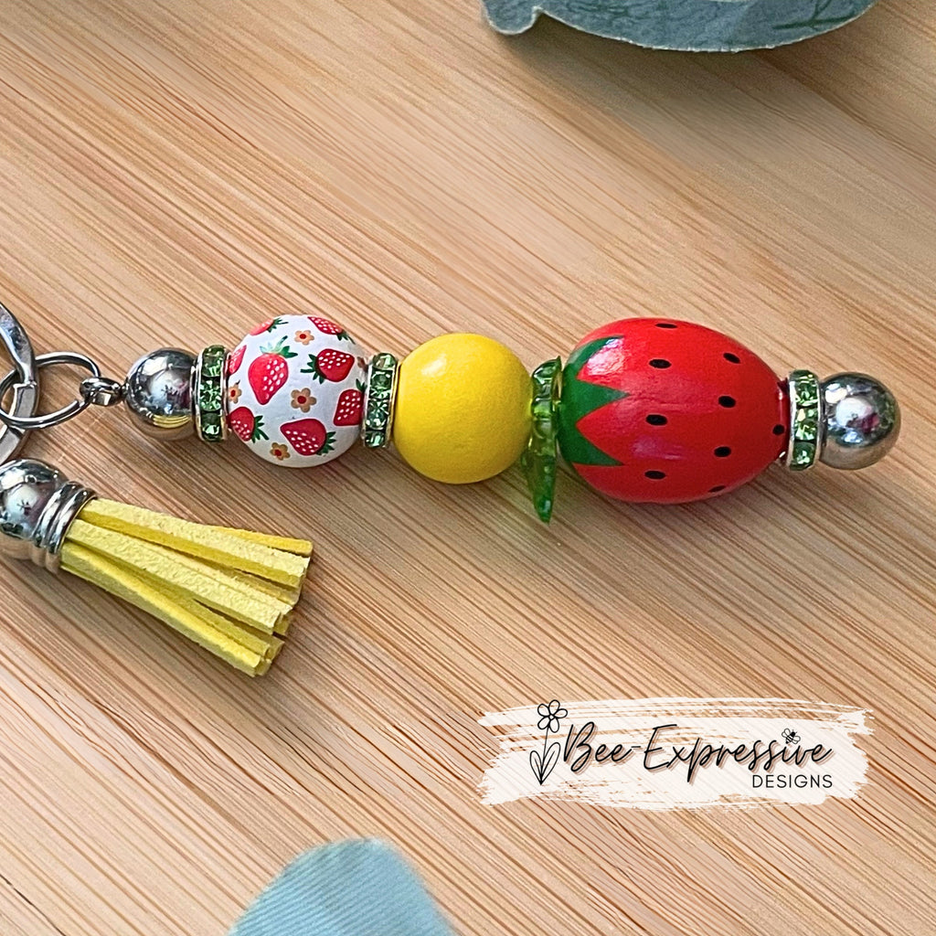 Adorable, strawberry beaded keychain!  Interchangeable beaded bar, lobster clasp, tassel, & butterfly charm! Comes with an acrylic leaf too!