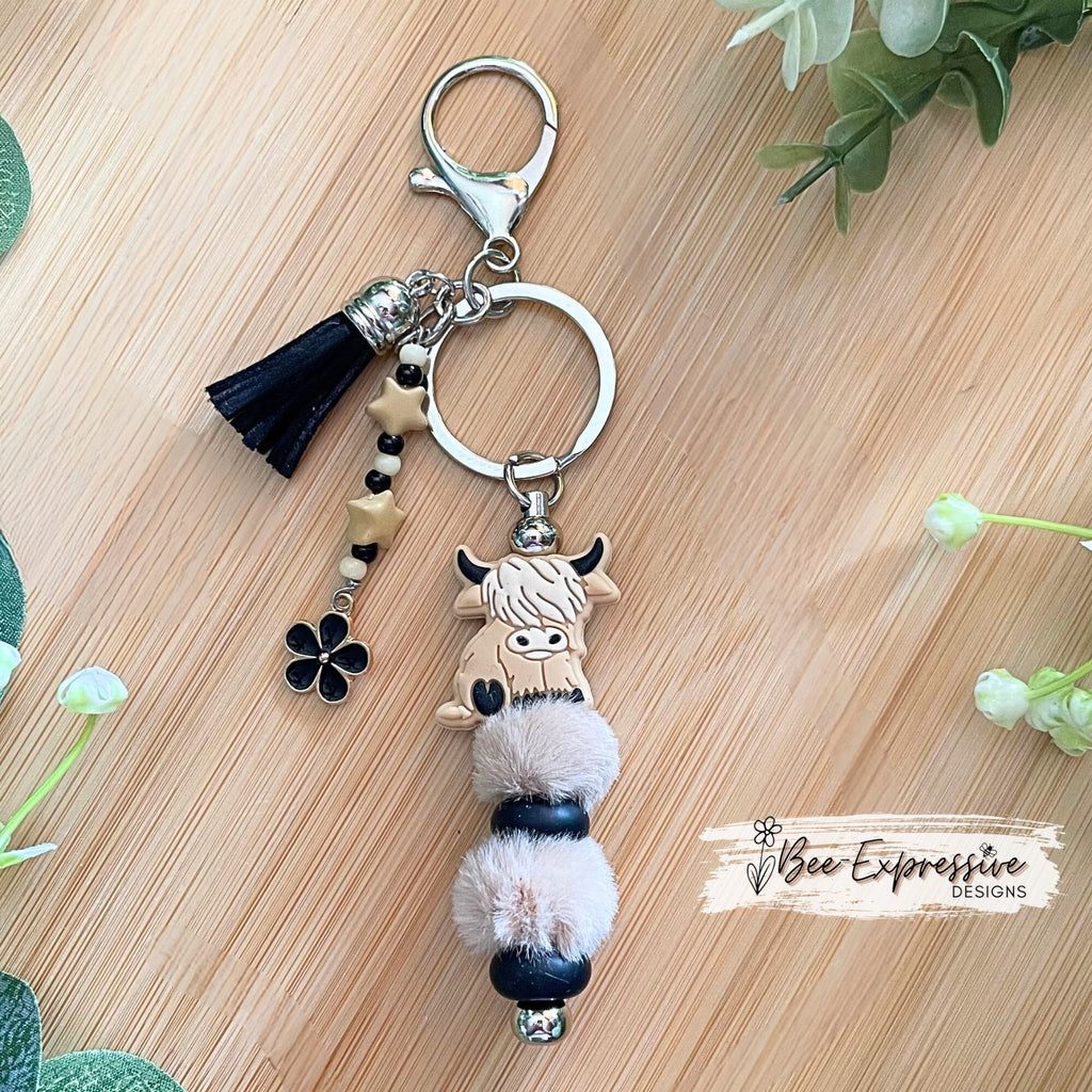 Adorable, handmade, bull cow keychain! Furry beads, silicone lentil spacers, stars, acrylic beaded tassel and black flower charm!