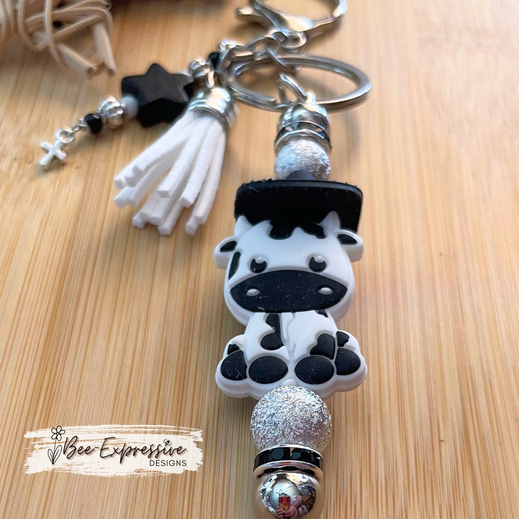 Handmade, ADORABLE, silicone COW with cowboy hat keychain! Lobster claw clasp, rhinestone spacers, beaded tassel w/ wood star & cross charm