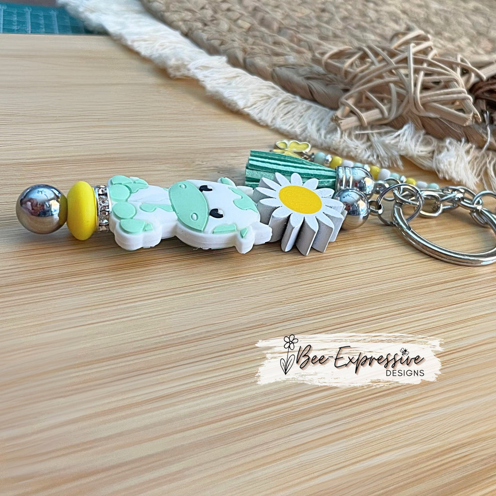 Handmade,  turquoise cow/bull keychain with wood sunflower!  Lobster claw clasp and metal bar, beaded tassel with butterfly charm!