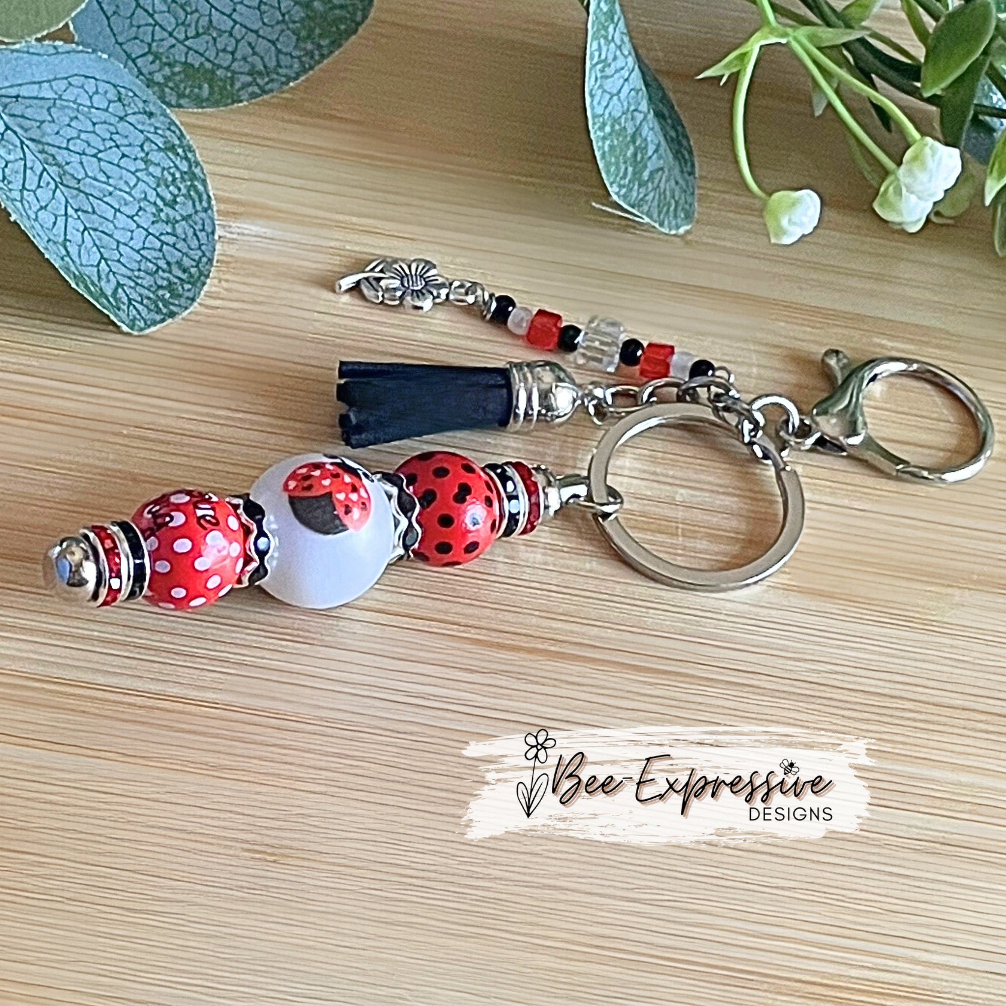 Handmade and unique, lady bug keychain!  Lobster claw clasp, wood printed beads, acrylic lady bug bead, rhinestones, flower charm pendant