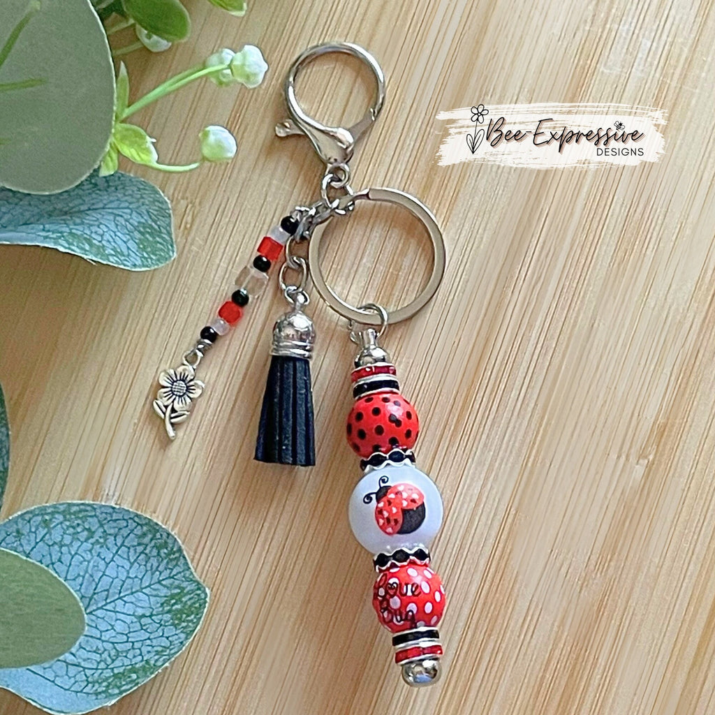 Handmade and unique, lady bug keychain!  Lobster claw clasp, wood printed beads, acrylic lady bug bead, rhinestones, flower charm pendant