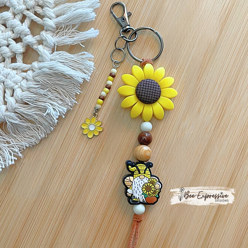 Handmade, unique, silicone sunflower gnome keychain!  Lobster clasp, suede cord, wood beads, beaded tassel with yellow daisy charm!
