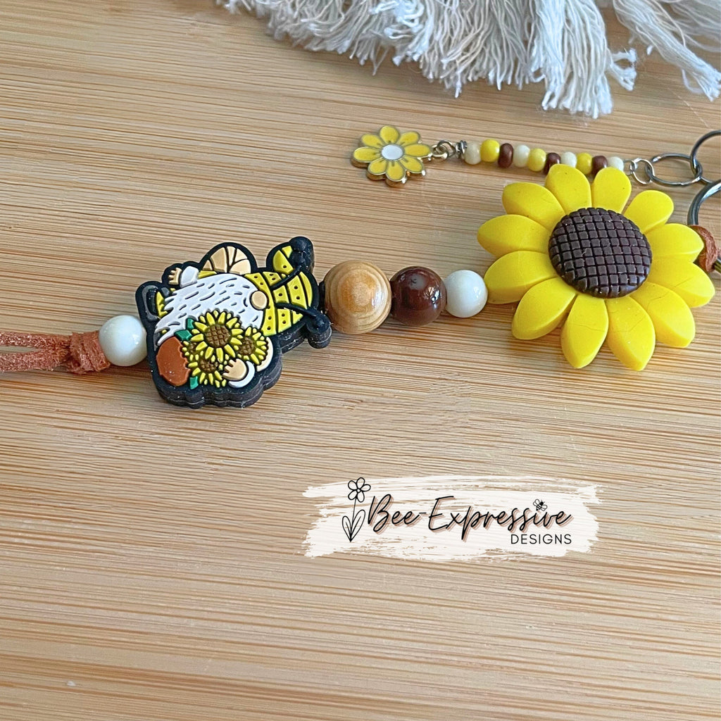 Handmade, unique, silicone sunflower gnome keychain!  Lobster clasp, suede cord, wood beads, beaded tassel with yellow daisy charm!