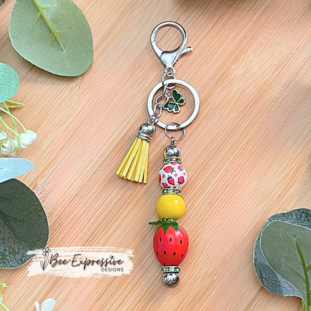 Adorable, strawberry beaded keychain!  Interchangeable beaded bar, lobster clasp, tassel, & butterfly charm! Comes with an acrylic leaf too!