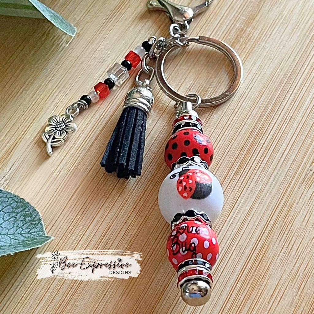 Handmade and unique, lady bug keychain!  Lobster claw clasp, wood printed beads, acrylic lady bug bead, rhinestones, flower charm pendant