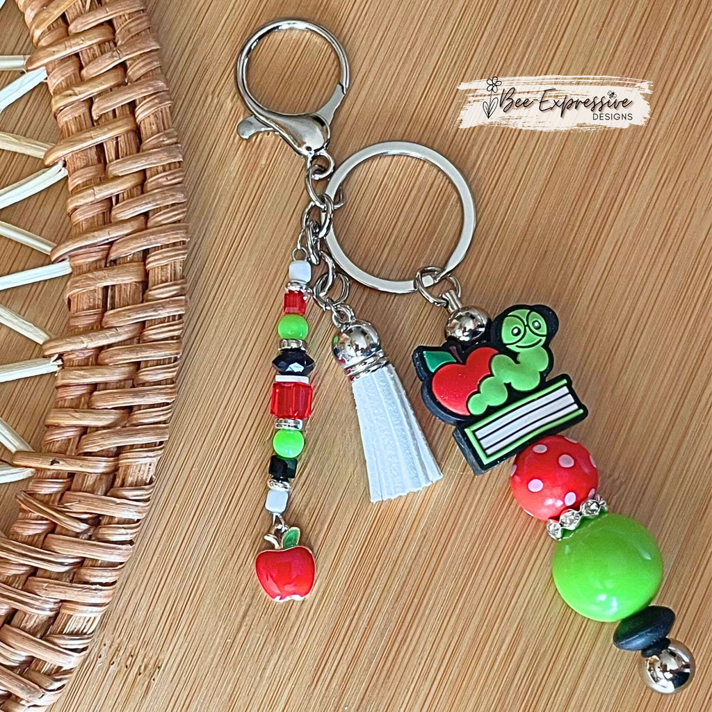 Handmade, unique, book worm teacher keychain! Lobster clasp, metal bar, 20” acrylic bead, beaded tassel with apple charm pendant!