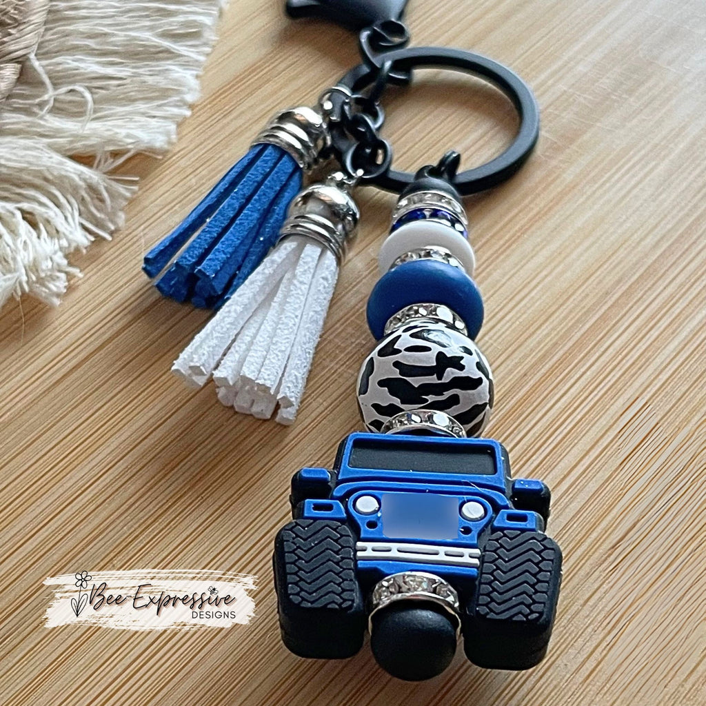 Unique and handmade, blue silicone 4x4 vehicle, metal keychain with a black animal print bead, silicone lentil beads and rhinestone spacers!