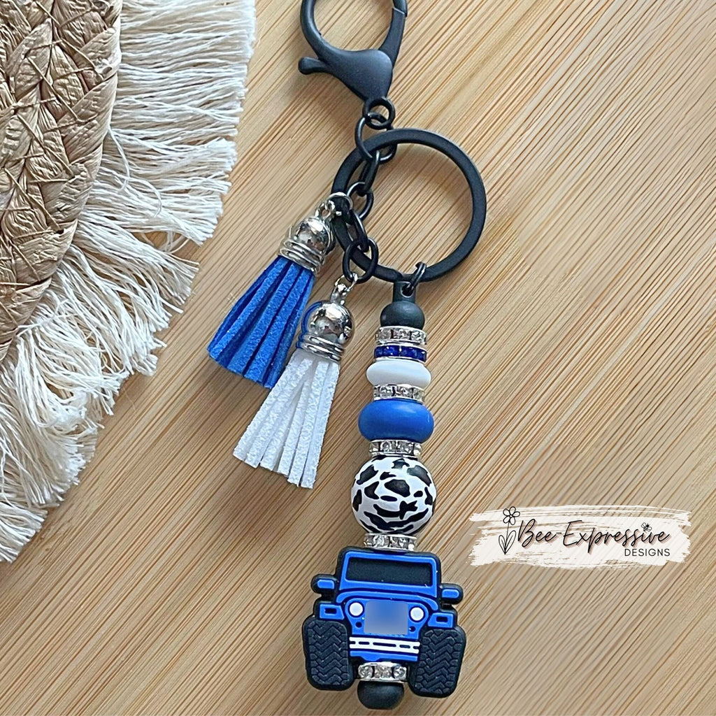Unique and handmade, blue silicone 4x4 vehicle, metal keychain with a black animal print bead, silicone lentil beads and rhinestone spacers!