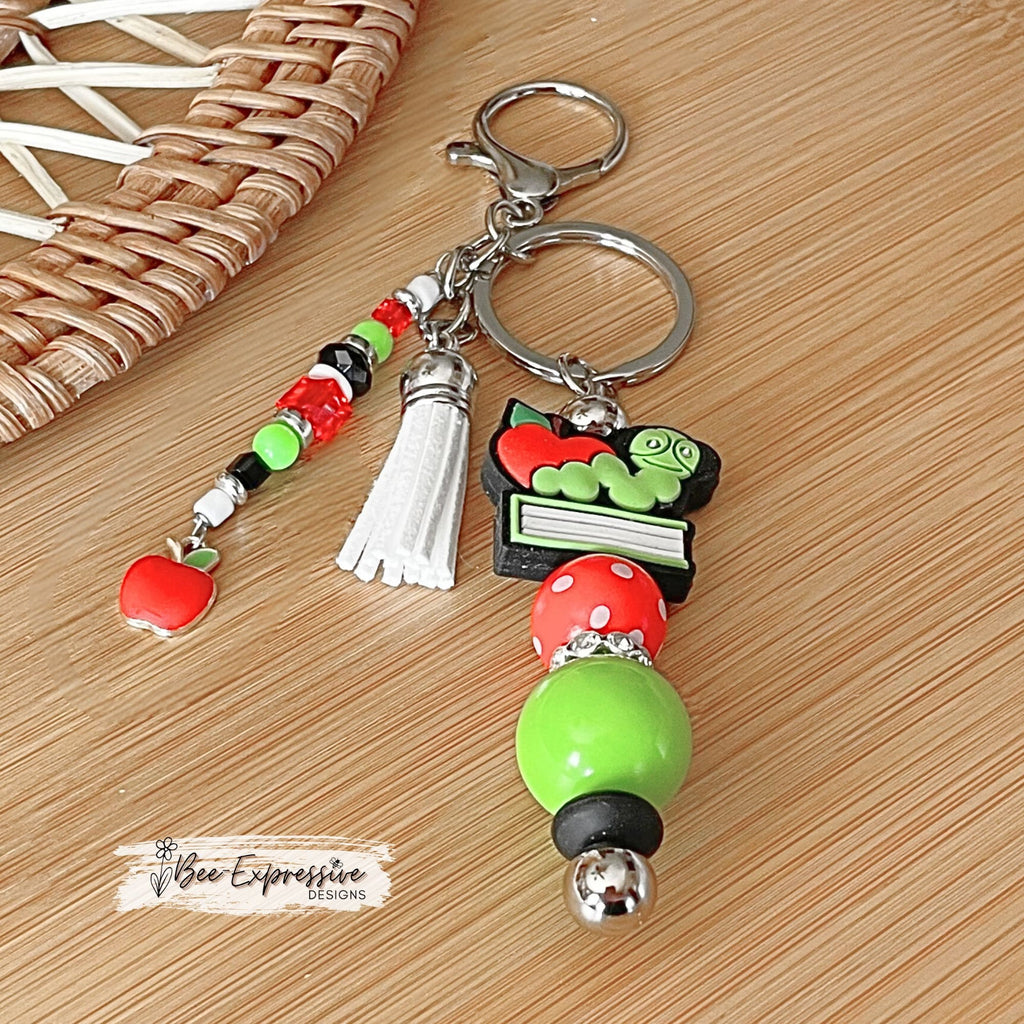 Handmade, unique, book worm teacher keychain! Lobster clasp, metal bar, 20” acrylic bead, beaded tassel with apple charm pendant!