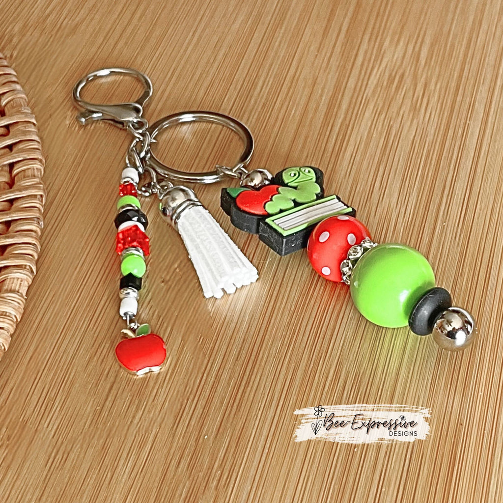 Handmade, unique, book worm teacher keychain! Lobster clasp, metal bar, 20” acrylic bead, beaded tassel with apple charm pendant!