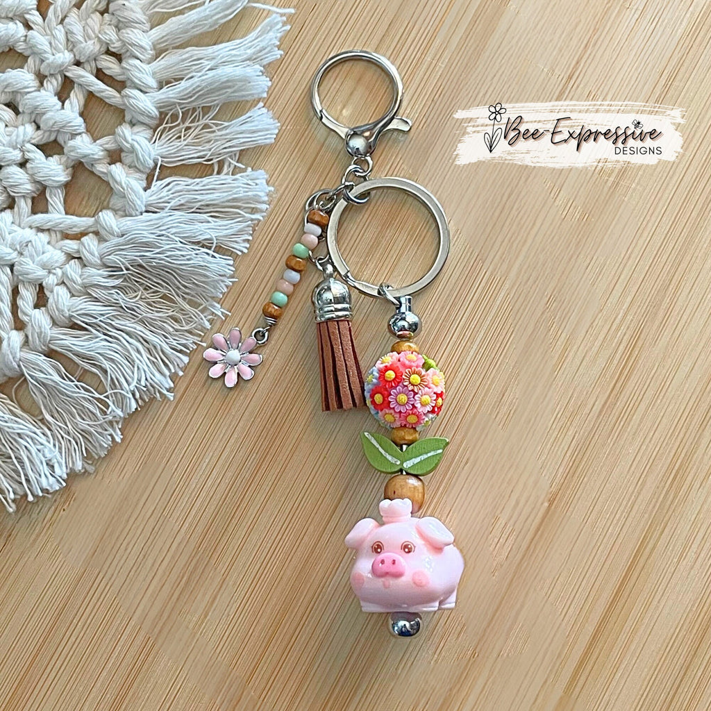 Adorable, handmade, pink pig metal keychain with multi floral bead!  Lobster claw clasp, bead bar, wood beads, beaded tasse pink daisy charm