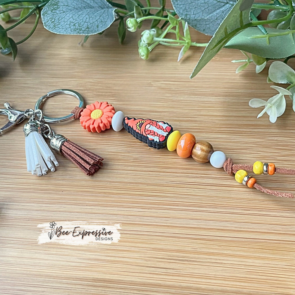 Handmade, unique, silicone sunflower gnome keychain!  Lobster clasp, suede cord, lentil beads, wood beads, girl gnome with orange braids