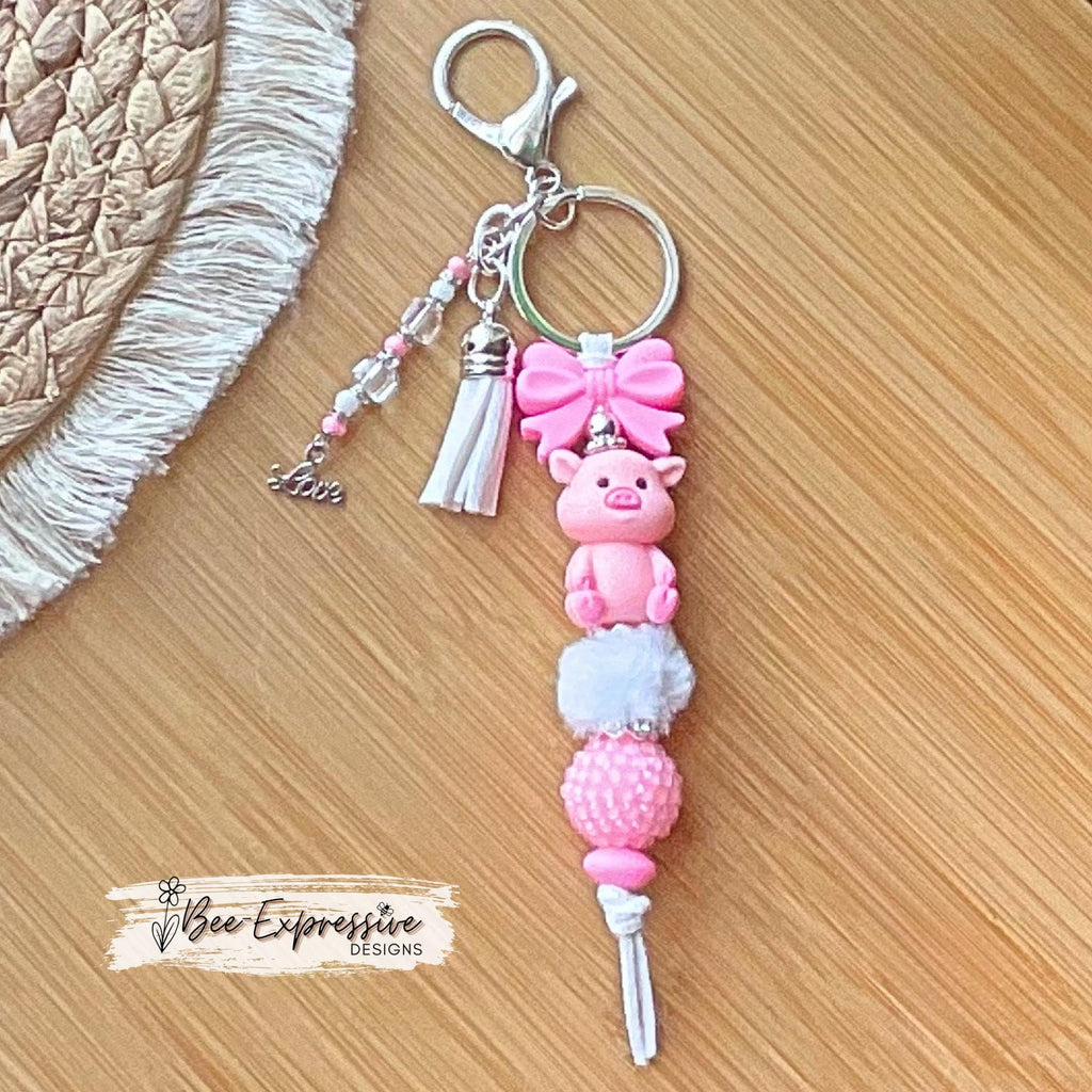 Beaded, 3D PIG keychain with a silicone pink bow! Lobster or swivel clasp, chunky rhinestone bead, fuzzy bead, beaded tassel & LOVE charm