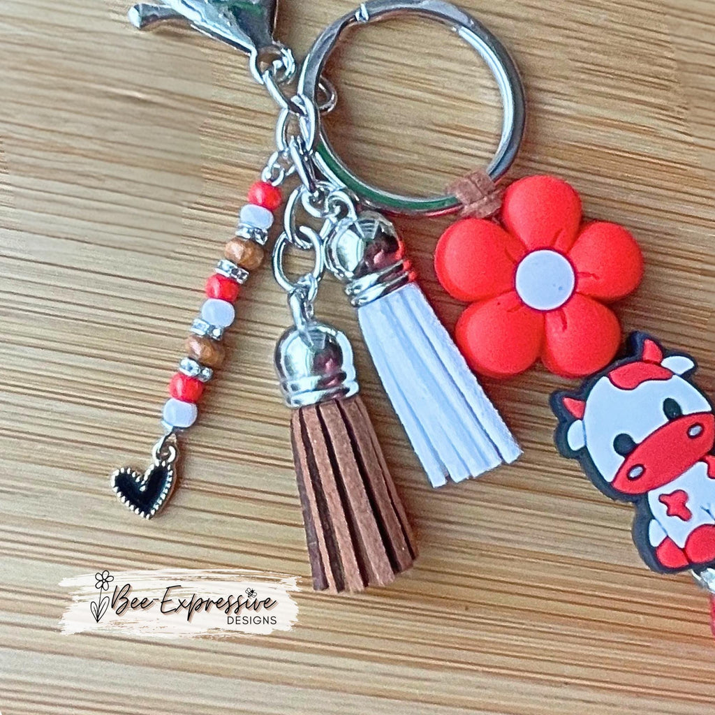 Handmade, RED COW keychain! Lobster or swivel clasp, suede cord chunky rhinestone bead, silicone daisy flower, beaded tassel w/ heart charm!