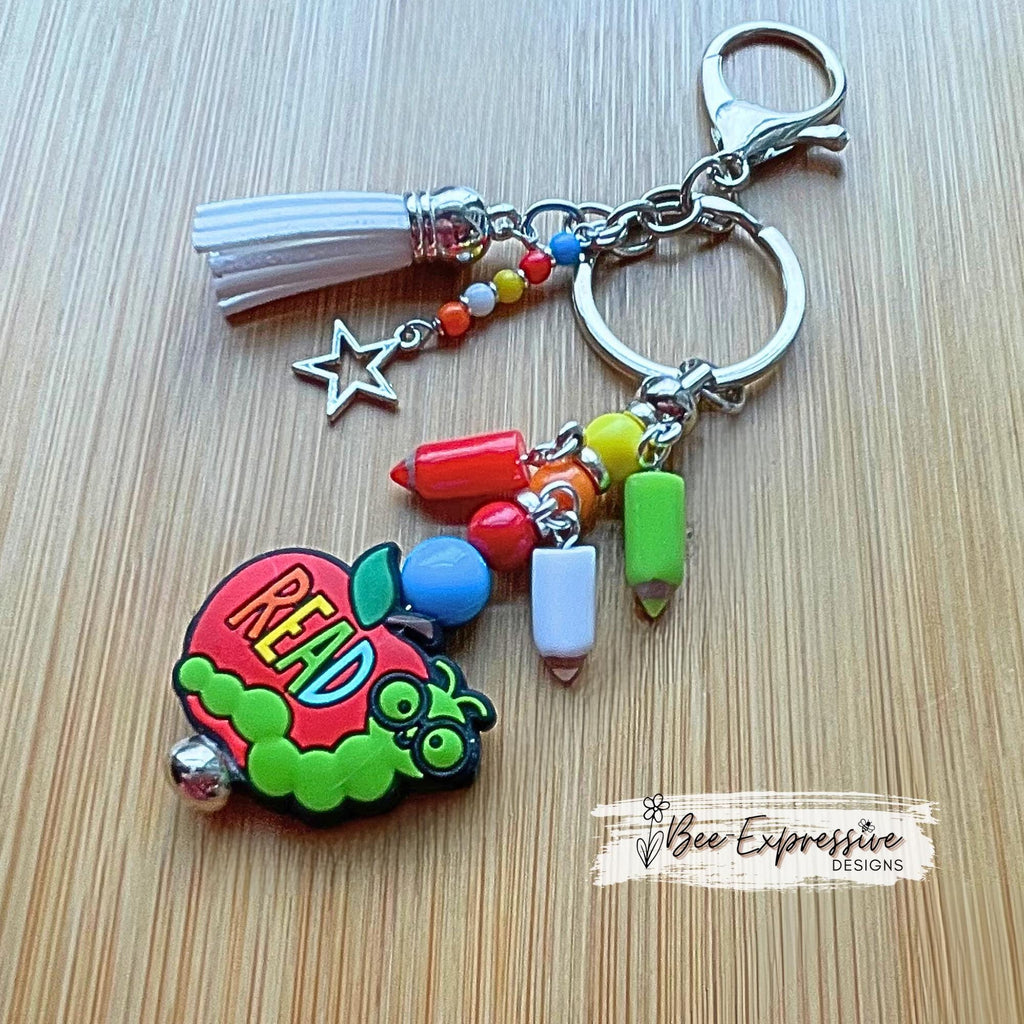 Handmade, unique, book worm teacher keychain! Lobster clasp, metal bar, acrylic beads, acrylic pencil charms, beaded tassel with star charm!