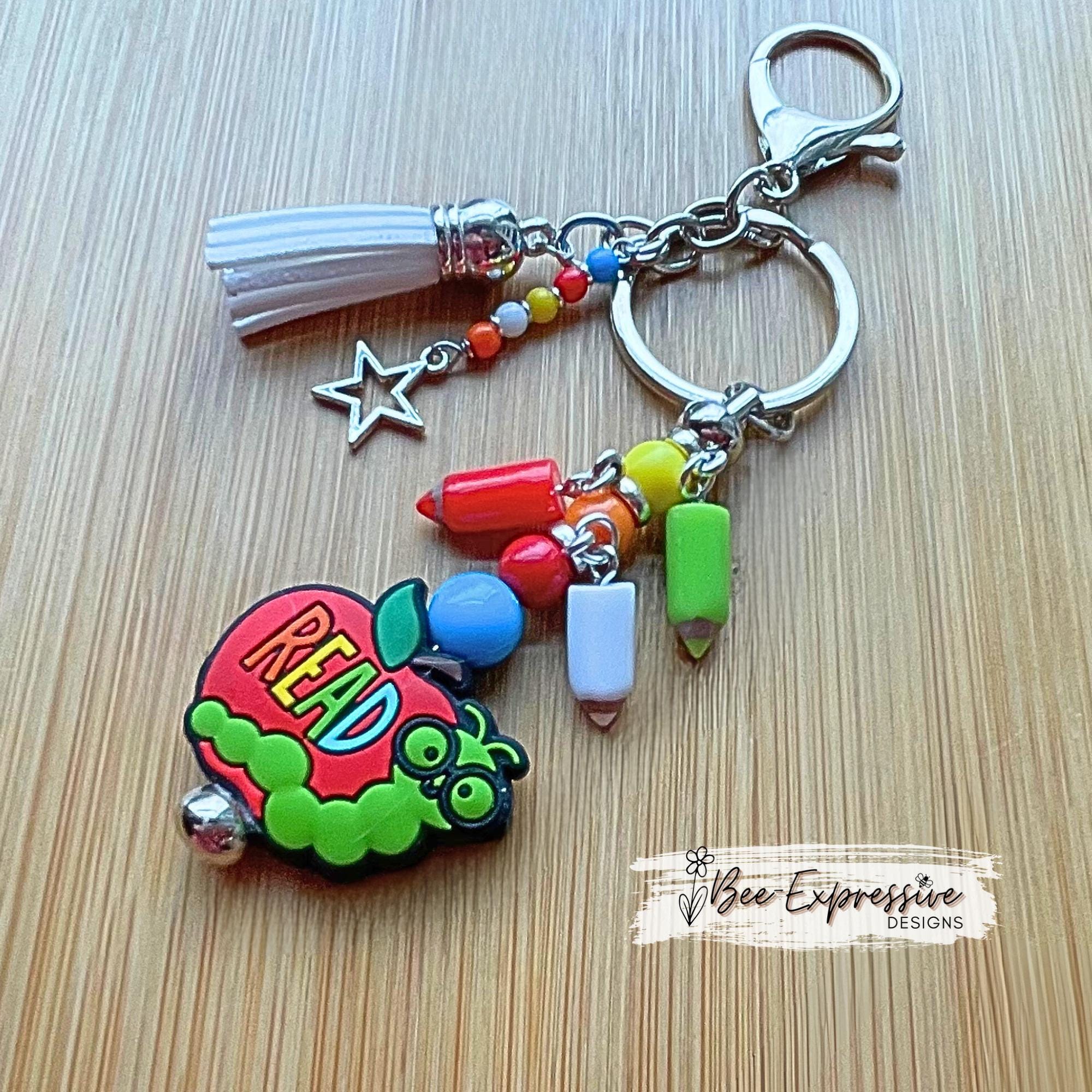 Handmade, unique, book worm teacher keychain! Lobster clasp, metal bar, acrylic beads, acrylic pencil charms, beaded tassel with star charm!