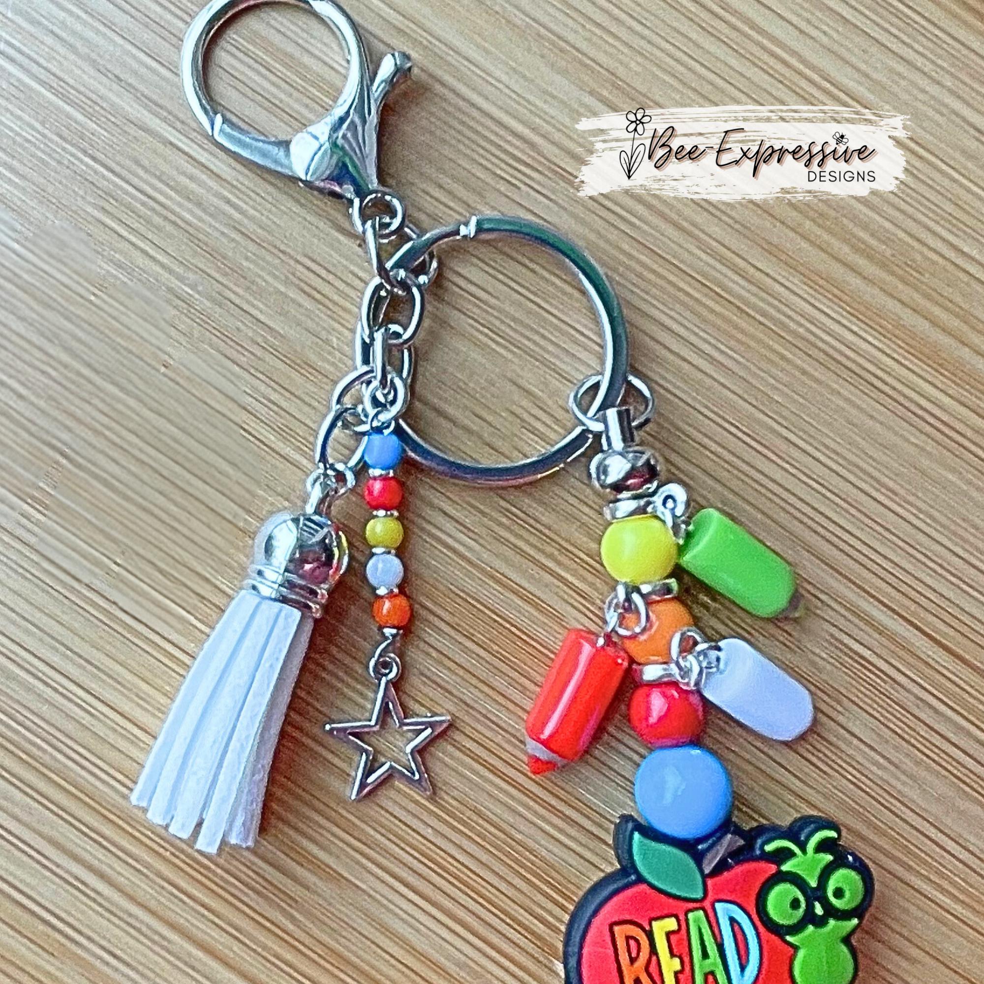 Handmade, unique, book worm teacher keychain! Lobster clasp, metal bar, acrylic beads, acrylic pencil charms, beaded tassel with star charm!
