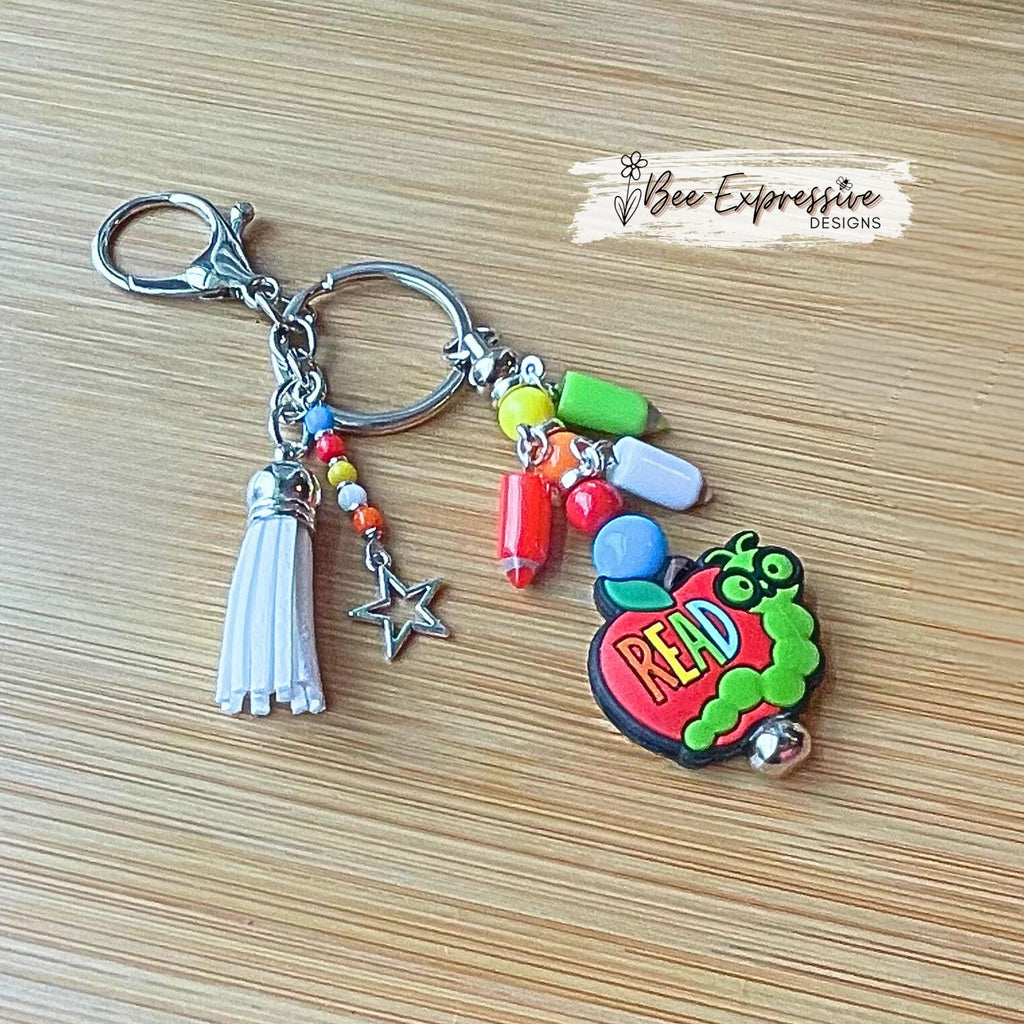 Handmade, unique, book worm teacher keychain! Lobster clasp, metal bar, acrylic beads, acrylic pencil charms, beaded tassel with star charm!